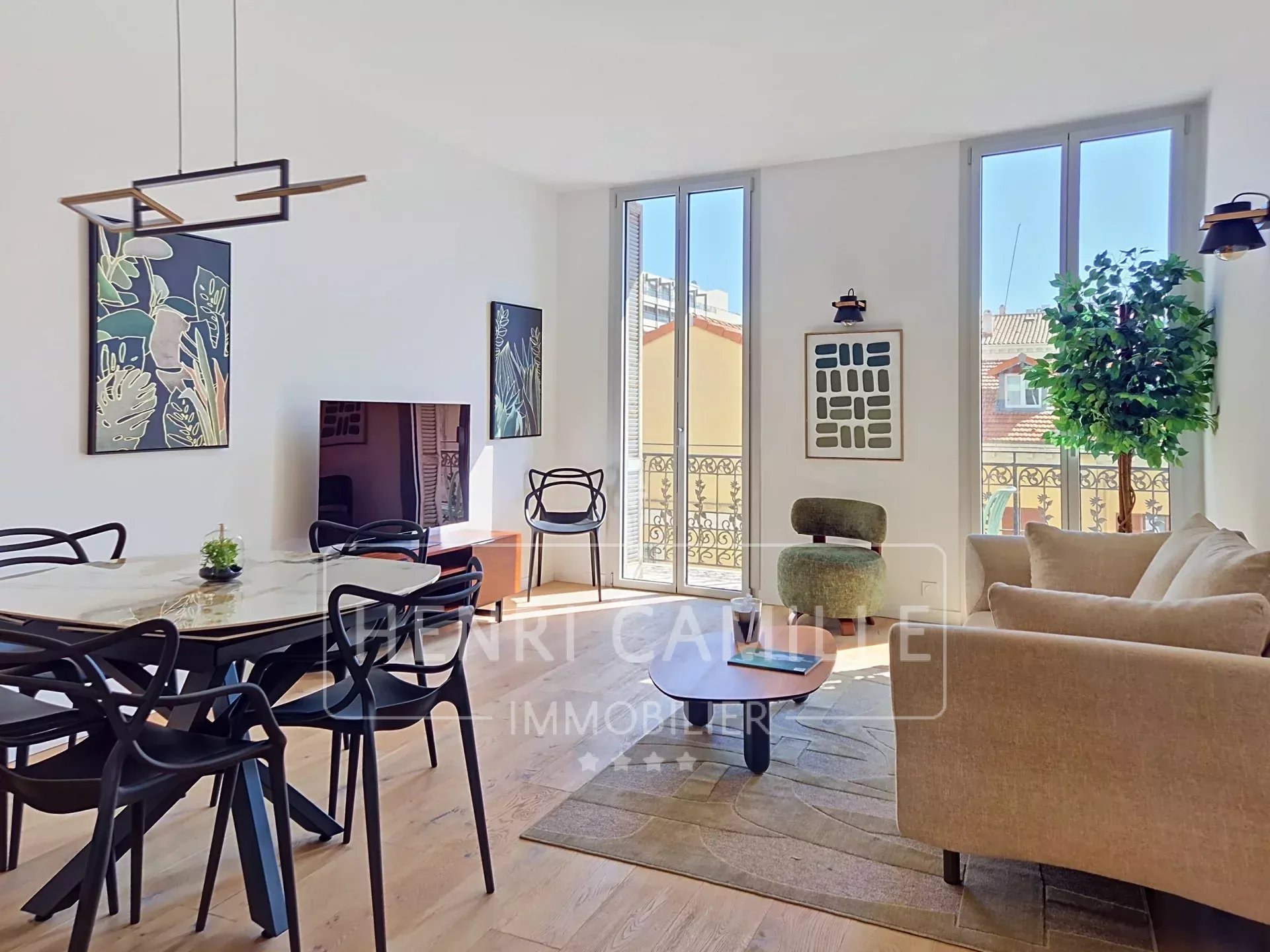 Appartement rénové à Cannes Intérieur d'un appartement rénové à Cannes avec salon lumineux, balcon et mobilier moderne.