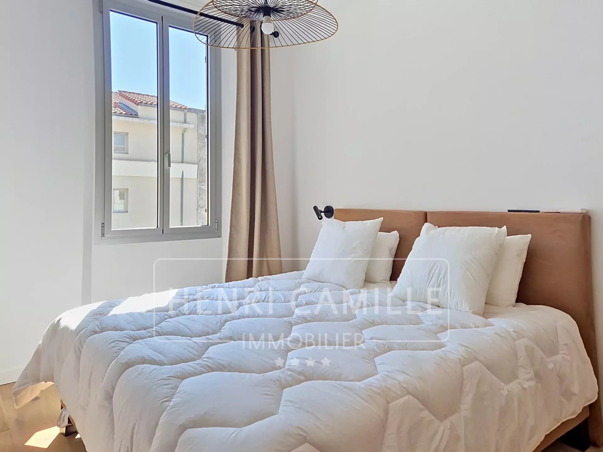 Chambre d’appartement à Cannes Chambre d'un appartement rénové à Cannes, avec lit double et fenêtre laissant entrer la lumière.