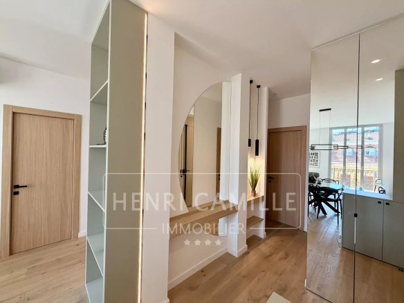 Intérieur d'un appartement rénové avec un miroir et des étagères, lumière naturelle