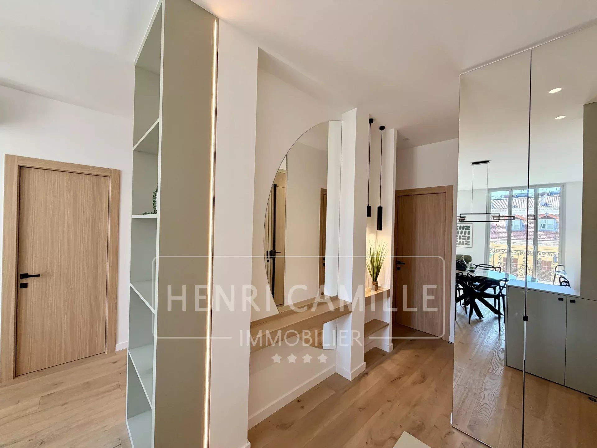 Appartement rénové à Cannes Intérieur d'un appartement rénové avec un miroir et des étagères, lumière naturelle