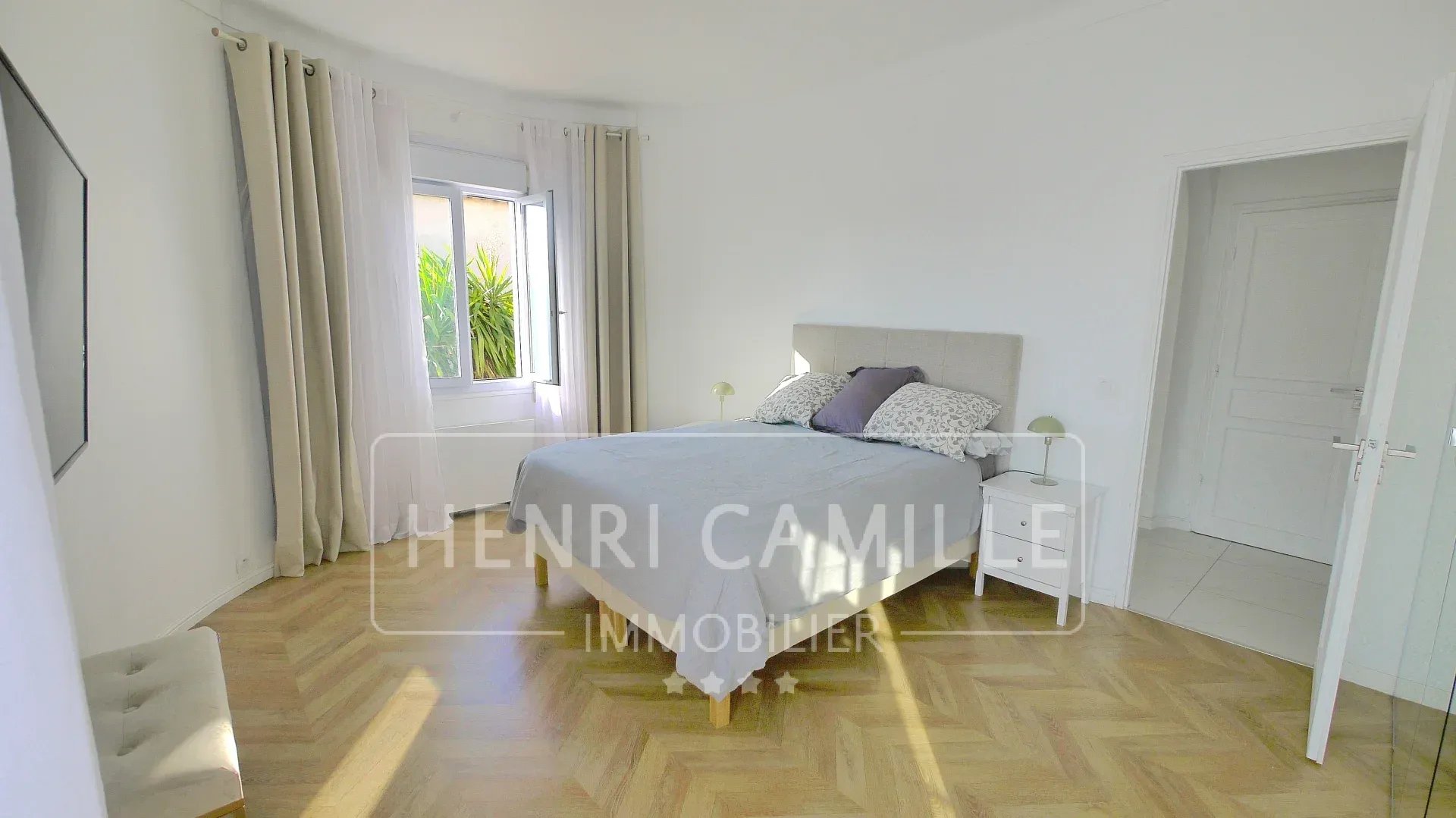 Room in a villa in Cannes Petit Juas, with double bed and window overlooking the outside.