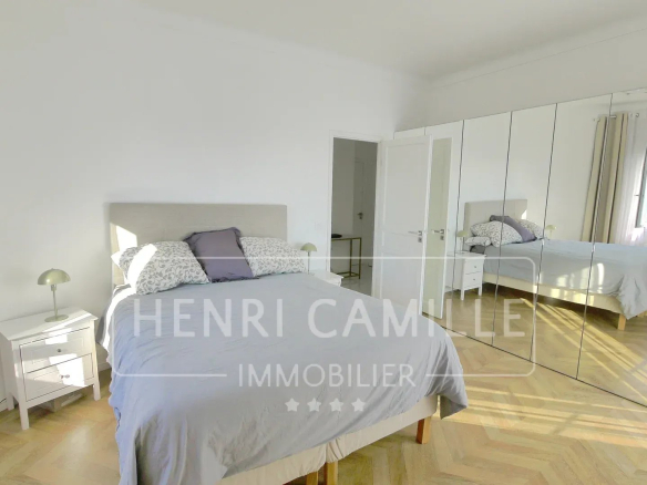 Room in a villa in Cannes Petit Juas with bed, mirror and natural light.