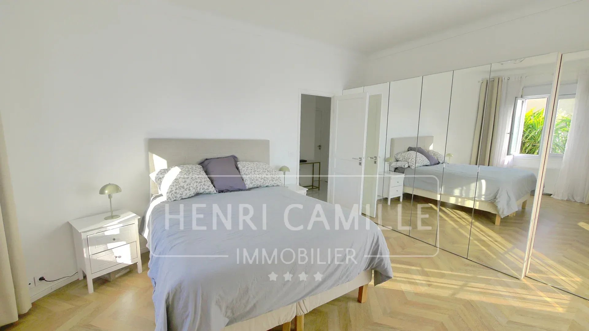 Room in a villa in Cannes Petit Juas with bed, mirror and natural light.