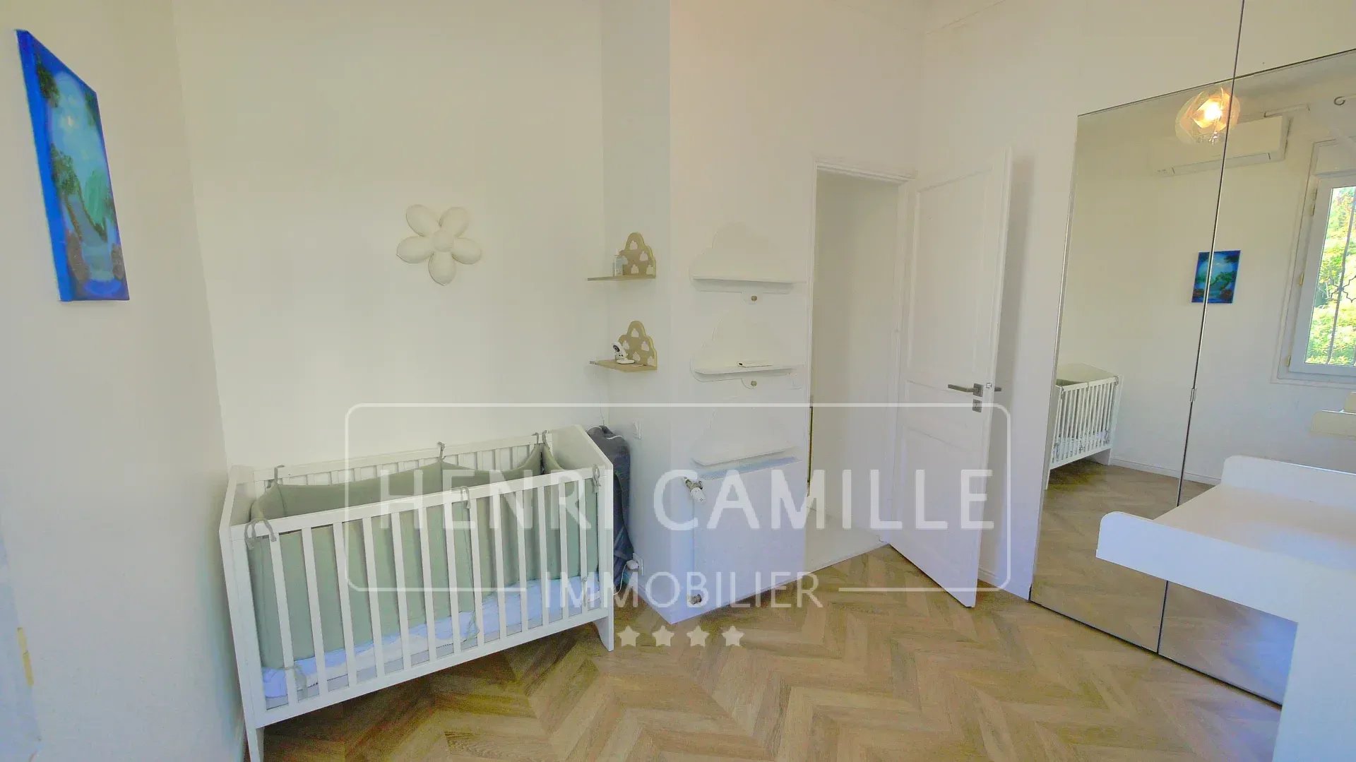 Children's room with a baby bed and minimalist decor.