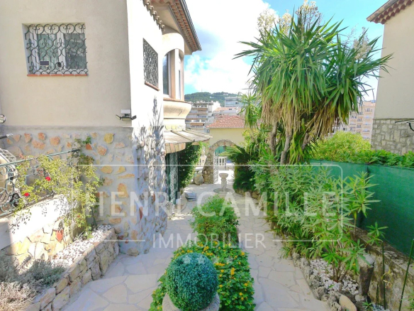 Driveway leading to a villa in Cannes Petit Juas, with garden and plants.