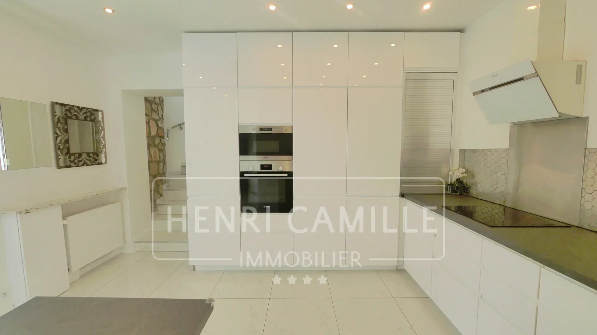 Modern and bright kitchen of a villa in Cannes Petit Juas with white furniture and integrated appliances.