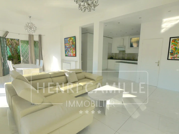 Interior of a modern villa in Cannes Petit Juas, bright living room with sofa and dining table.