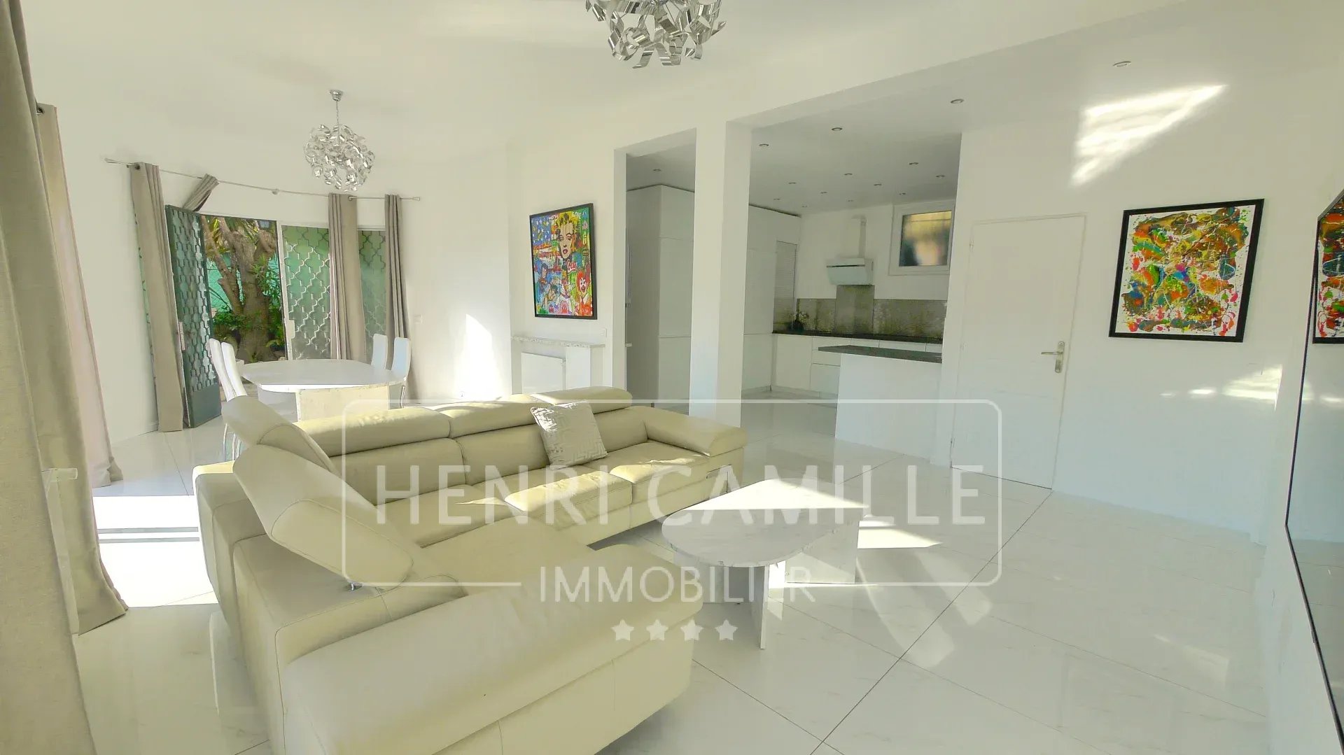 Interior of a modern villa in Cannes Petit Juas, bright living room with sofa and dining table.