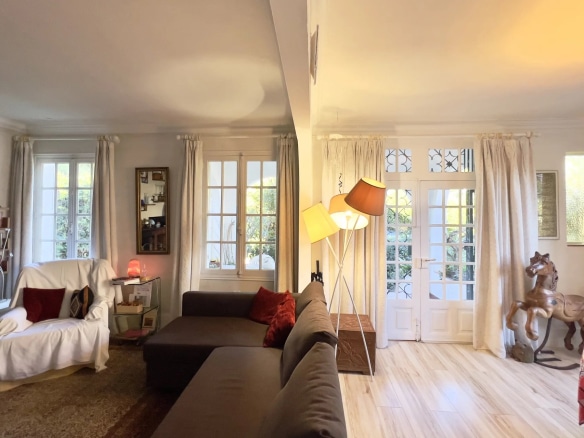 Interior of a villa in Cap d'Antibes with a bright living room and windows opening onto the outside.
