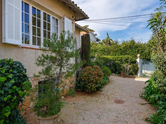 Entrance to a villa with a garden in Cap d'Antibes, surrounded by greenery.
