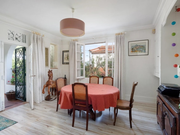 Interior of a villa in Cap d'Antibes with a dining room and bright windows.