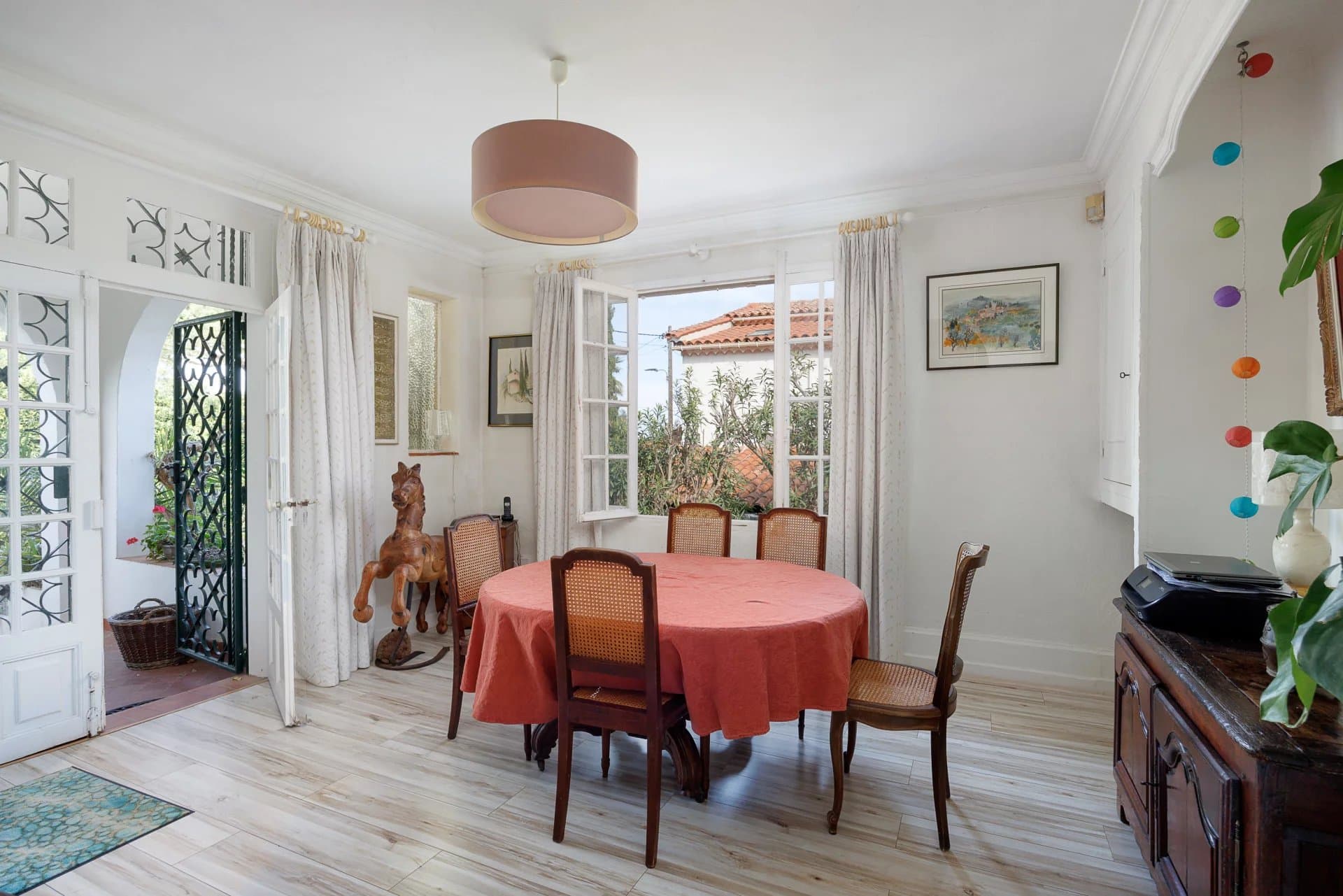 Interior of a villa in Cap d'Antibes with a dining room and bright windows.