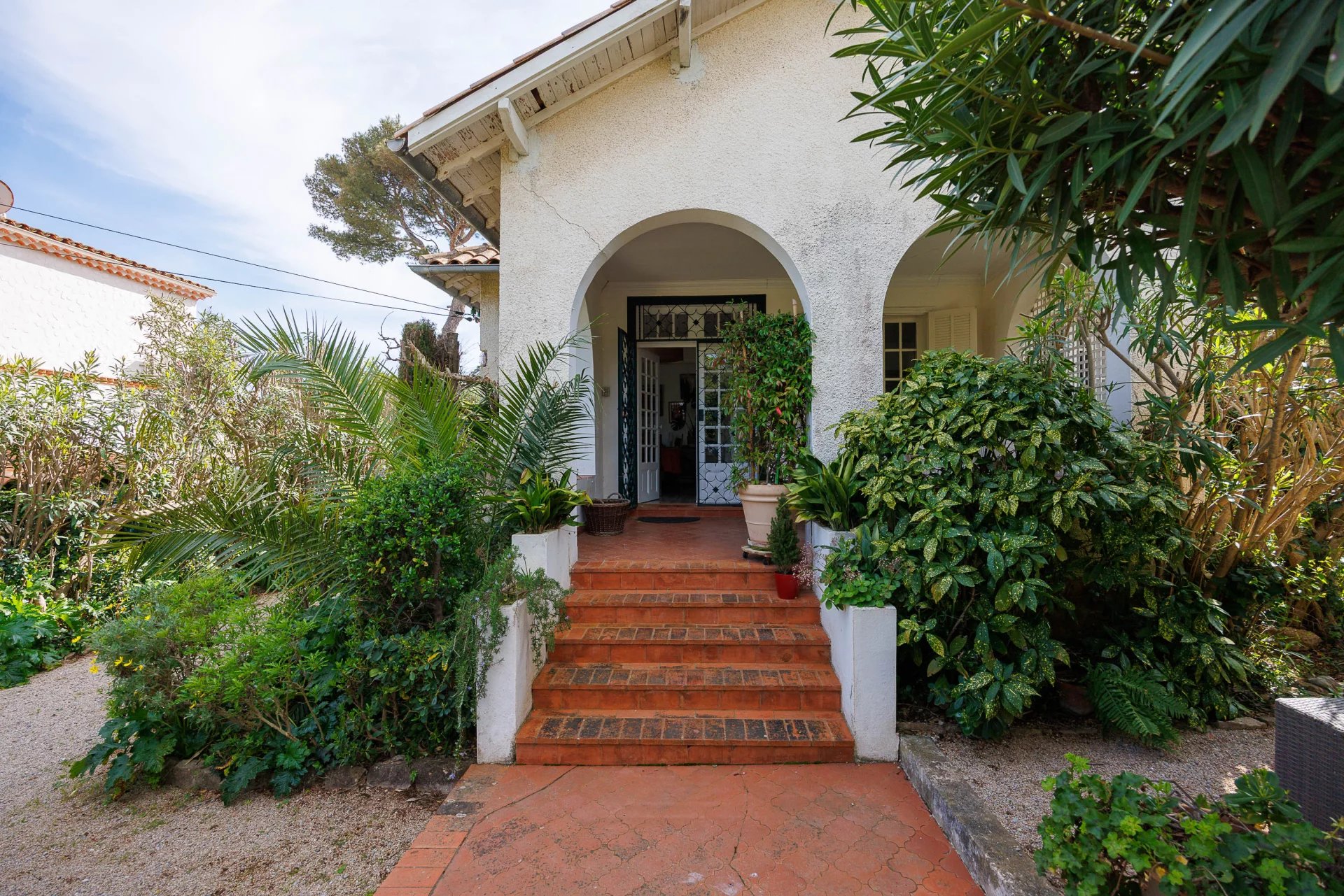 Entrance to a villa with a green garden in Cap d'Antibes.