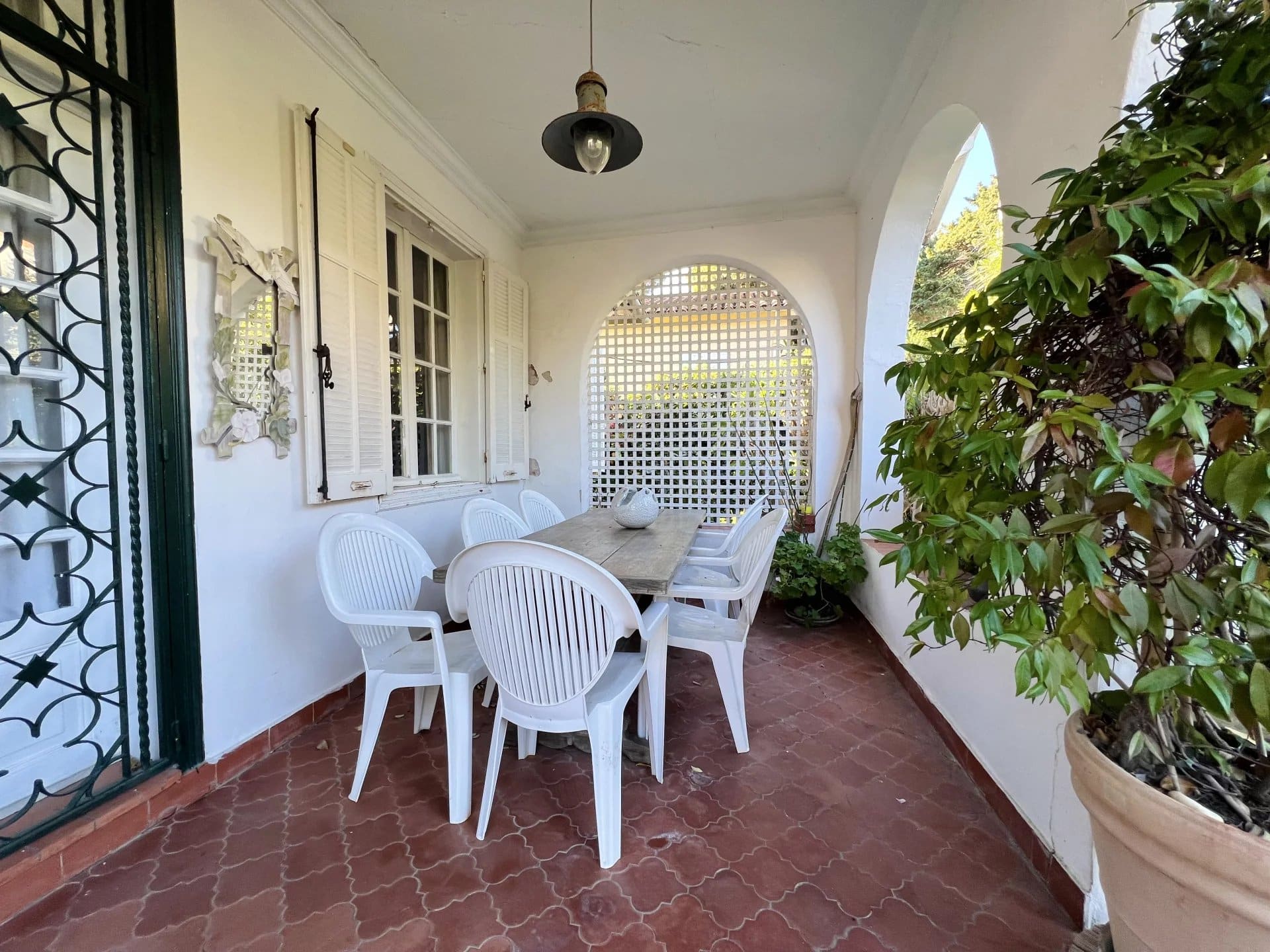 Terrace of a villa in Cap d'Antibes with a table and white chairs.