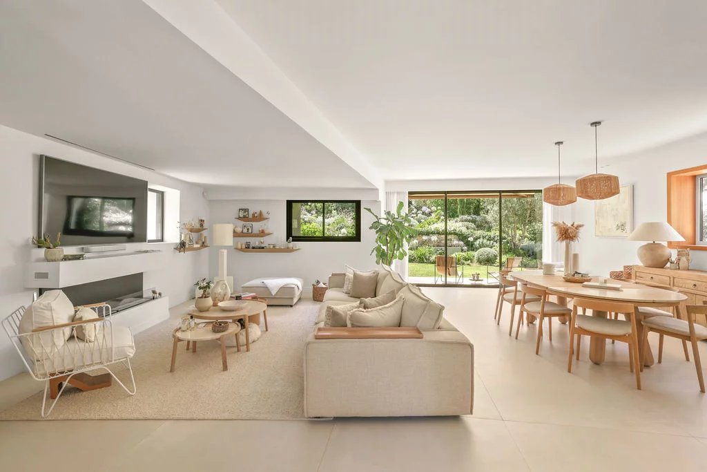 Interior of a contemporary villa Interior of a modern villa with bright living room and dining room, garden view.