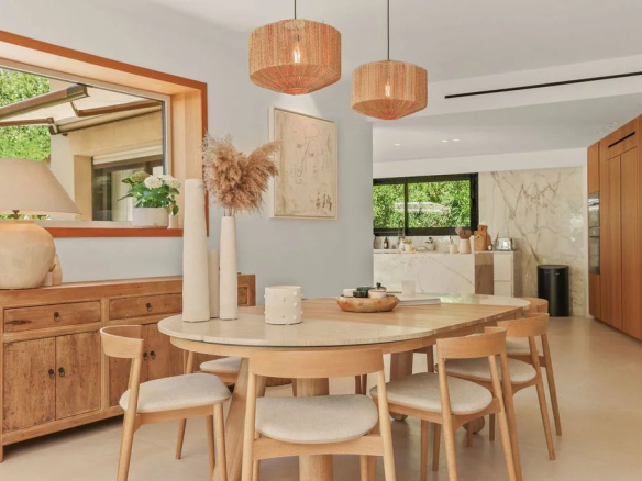 Interior of a modern villa with dining room and open kitchen, tastefully decorated.