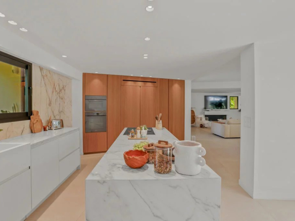 Modern interior of a villa with open kitchen and central marble island.