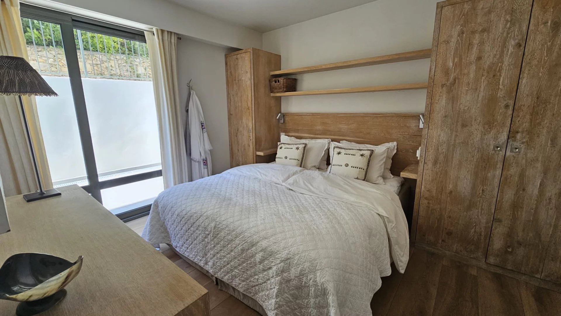 Apartment room in Antibes Room in a bright apartment with double bed and wooden furniture, overlooking a garden.
