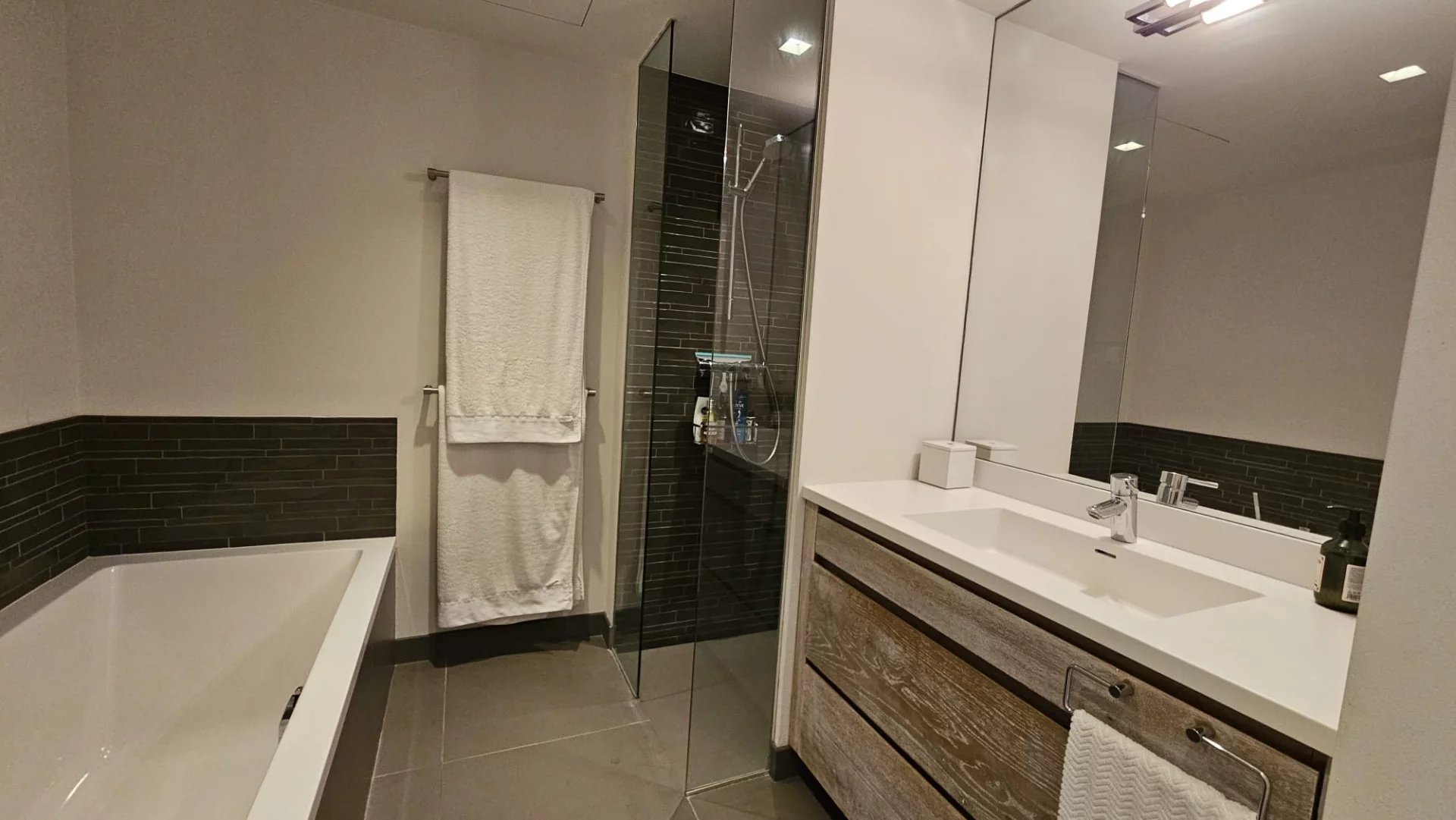 Modern bathroom Modern bathroom with bathtub and shower, tiled walls and wooden vanity unit.