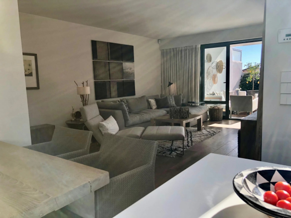 Interior of a bright apartment with a modern living room and access to a terrace.