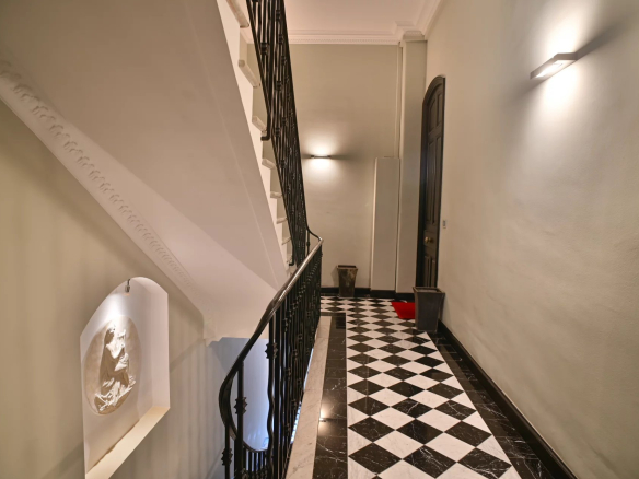 Staircase of a Belle Époque building in Cannes with a black and white checkered floor.