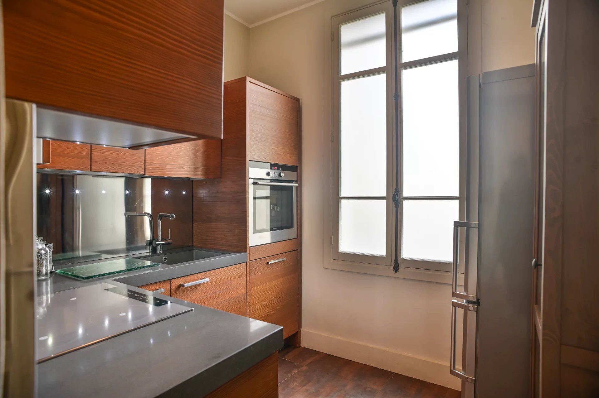Kitchen of a Belle Époque apartment in Cannes Modern kitchen with wooden elements and integrated appliances.