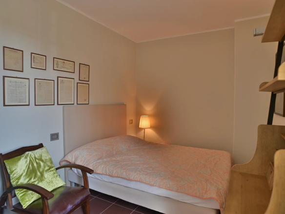 Room in a renovated apartment in a Belle Époque building in Cannes, with bed and armchair.