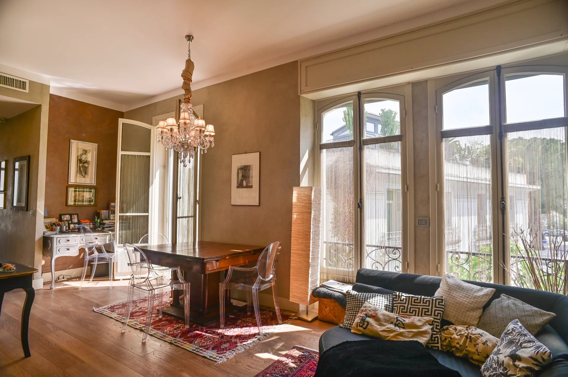 Belle Époque apartment in Cannes Interior of a Belle Époque apartment in Cannes, with a bright living room and a wooden dining table.
