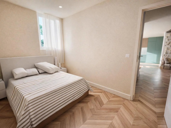 Chambre d'un appartement rénové à Antibes avec un lit et un sol en parquet.