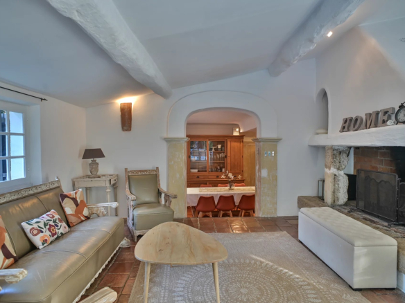 Intérieur d'un salon rénové d'un ancien moulin à Cannes avec cheminée et mobilier élégant.