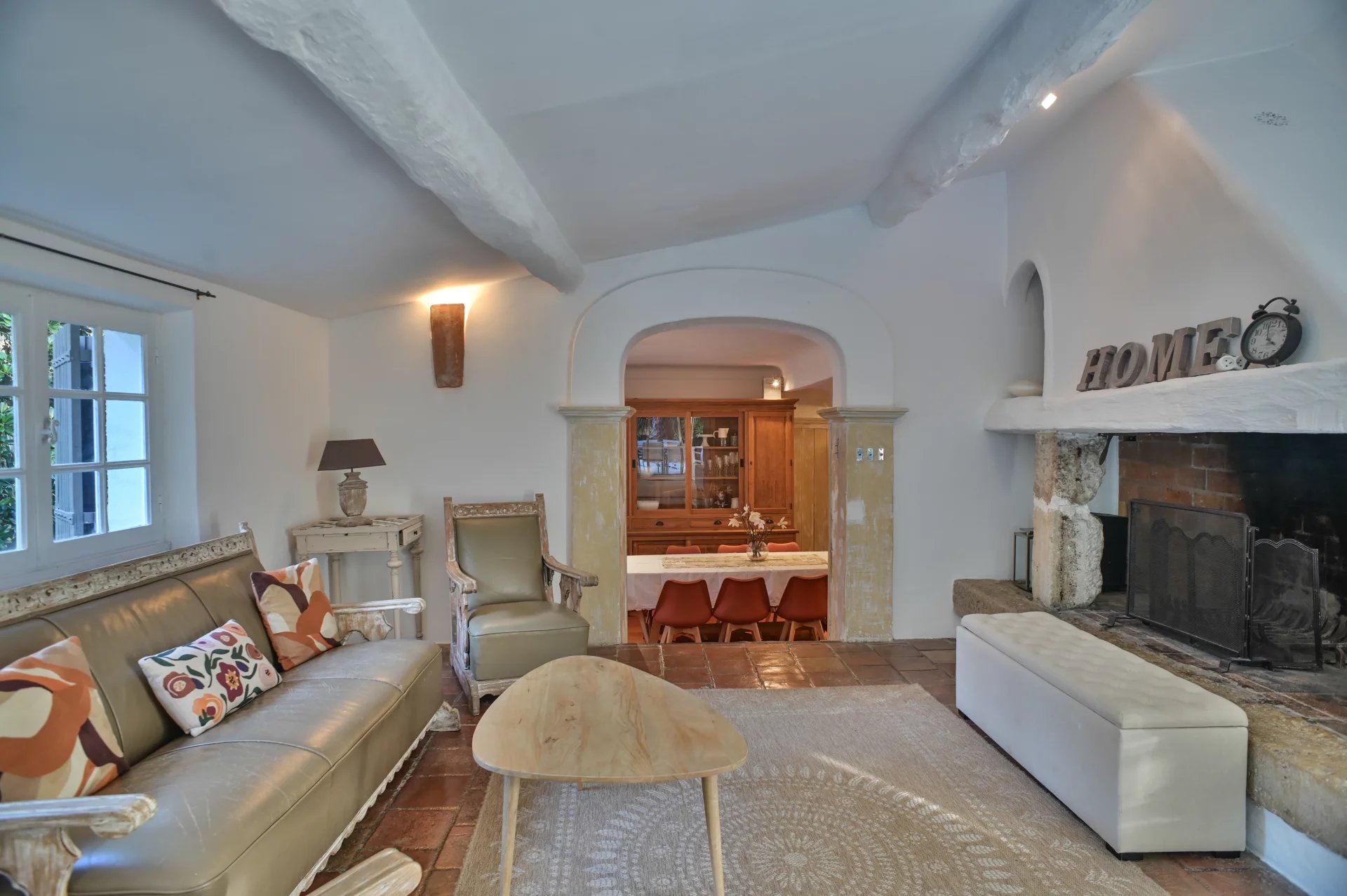 Intérieur d'un salon rénové d'un ancien moulin à Cannes avec cheminée et mobilier élégant.