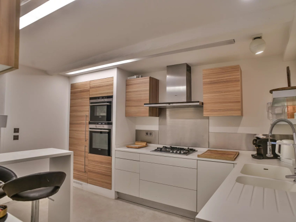 Cuisine moderne avec équipements intégrés et plan de travail en blanc.