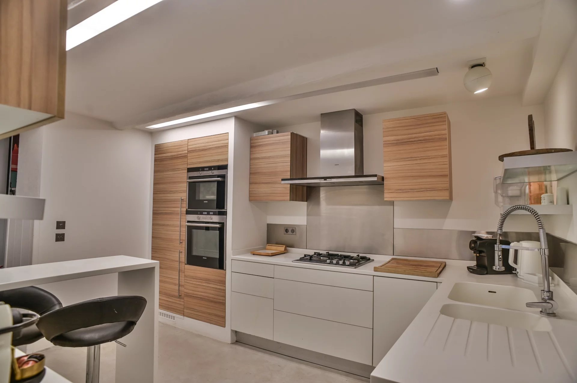 Cuisine moderne avec équipements intégrés et plan de travail en blanc.