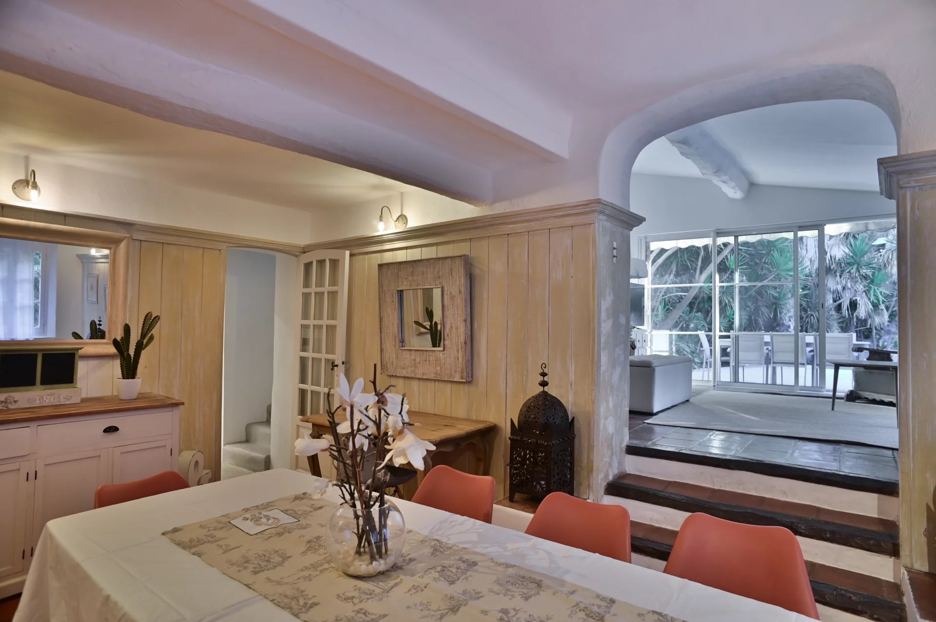 Intérieur d'une propriété rénovée avec une table à manger et un accès à un jardin.