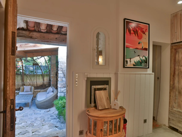 Intérieur d'un ancien moulin rénové avec accès à un jardin et une piscine.
