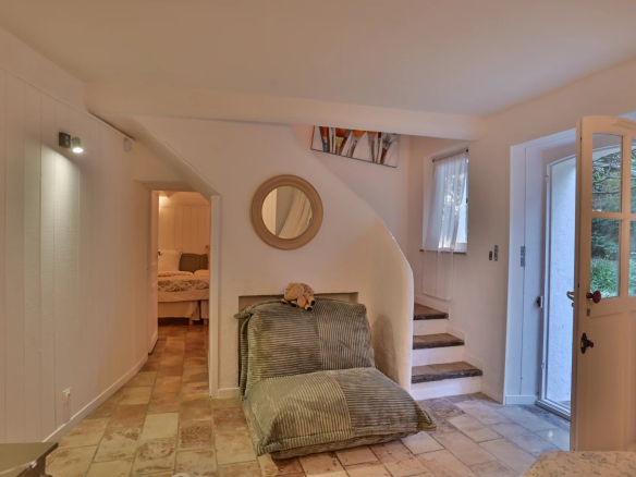 Intérieur d'une propriété rénovée avec un espace de vie lumineux et un escalier menant à d'autres pièces.