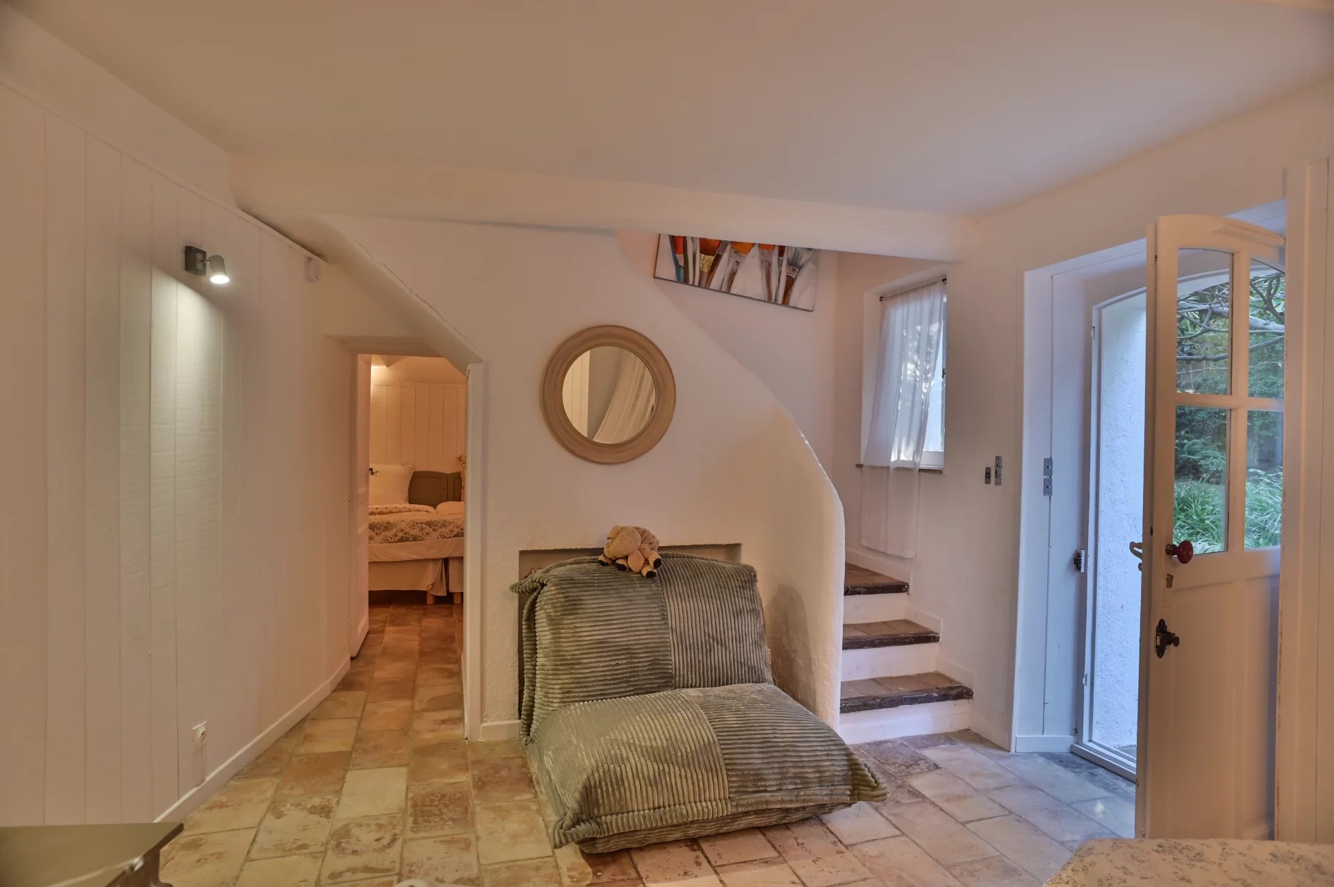 Intérieur d'une propriété rénovée avec un espace de vie lumineux et un escalier menant à d'autres pièces.