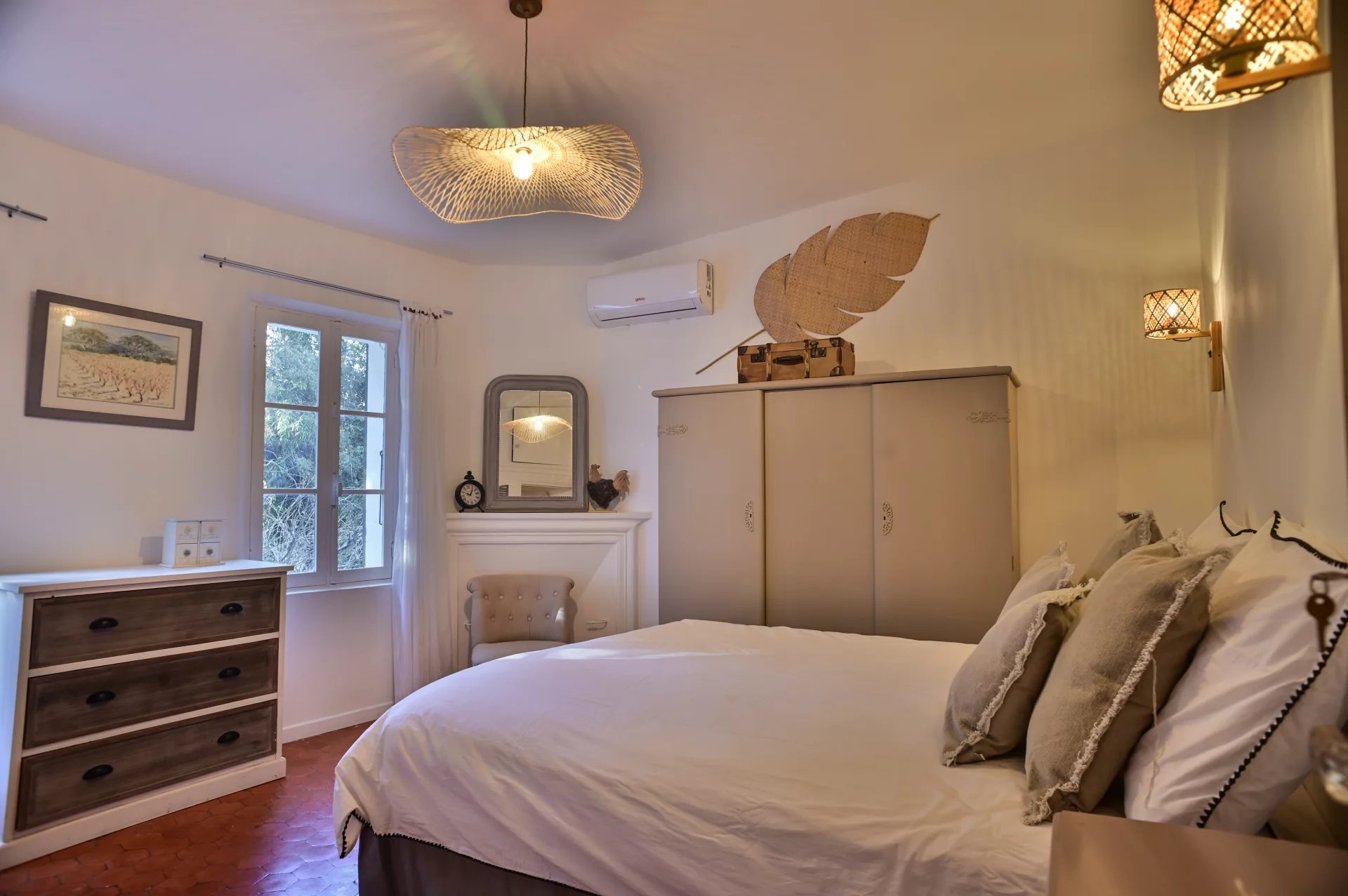 Chambre d'une propriété rénovée avec lit double et mobilier élégant, lumière naturelle.
