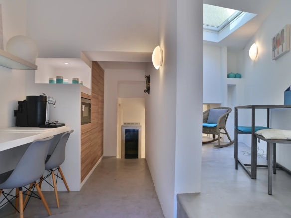 Intérieur rénové d'un moulin du XIXe siècle à Cannes, avec espace cuisine et coin salon.