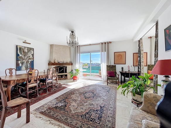 Salon lumineux d'un appartement à Antibes avec vue sur la mer et grandes fenêtres.