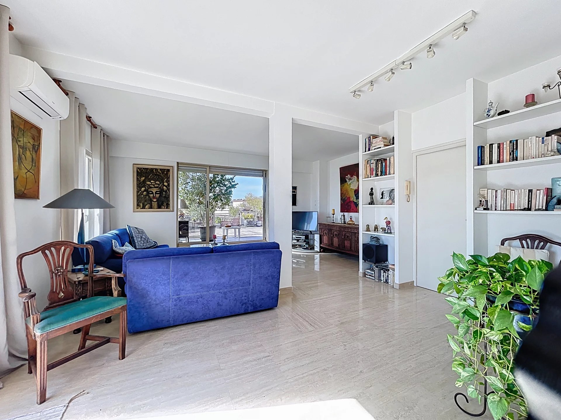 Appartement 3-4 pièces à Antibes Intérieur d'un appartement spacieux avec salon, bibliothèque et grandes fenêtres à Antibes.