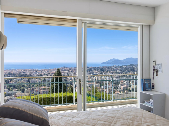 Chambre avec vue mer à Le Cannet, fenêtres ouvertes sur un panorama côtier.