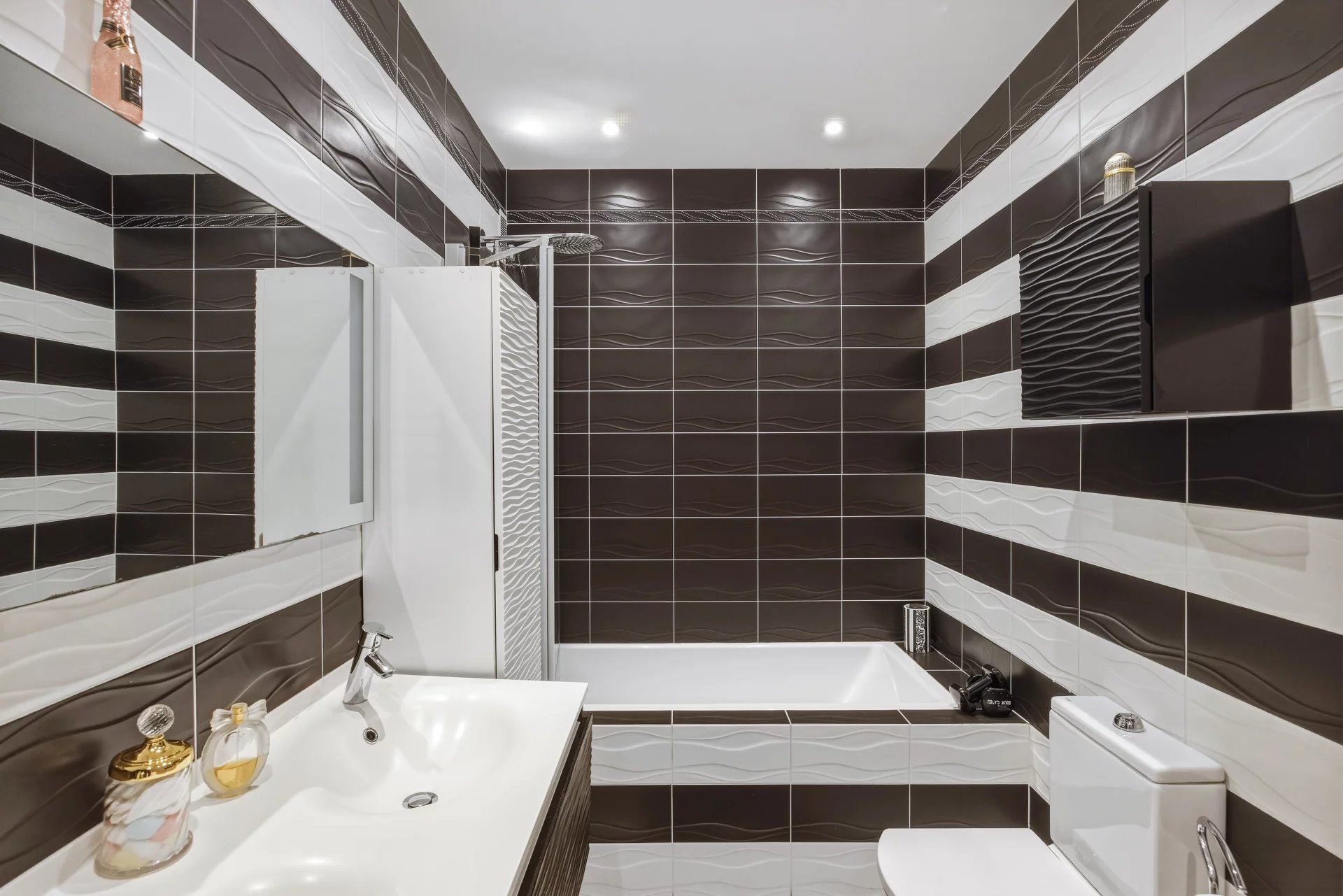 Salle de bain moderne Salle de bain moderne avec baignoire, lavabo et carrelage noir et blanc.