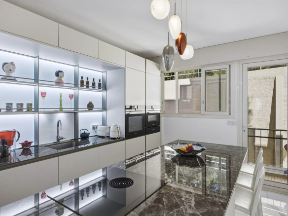 Cuisine moderne avec plan de travail en marbre et éclairage design dans un appartement de luxe.