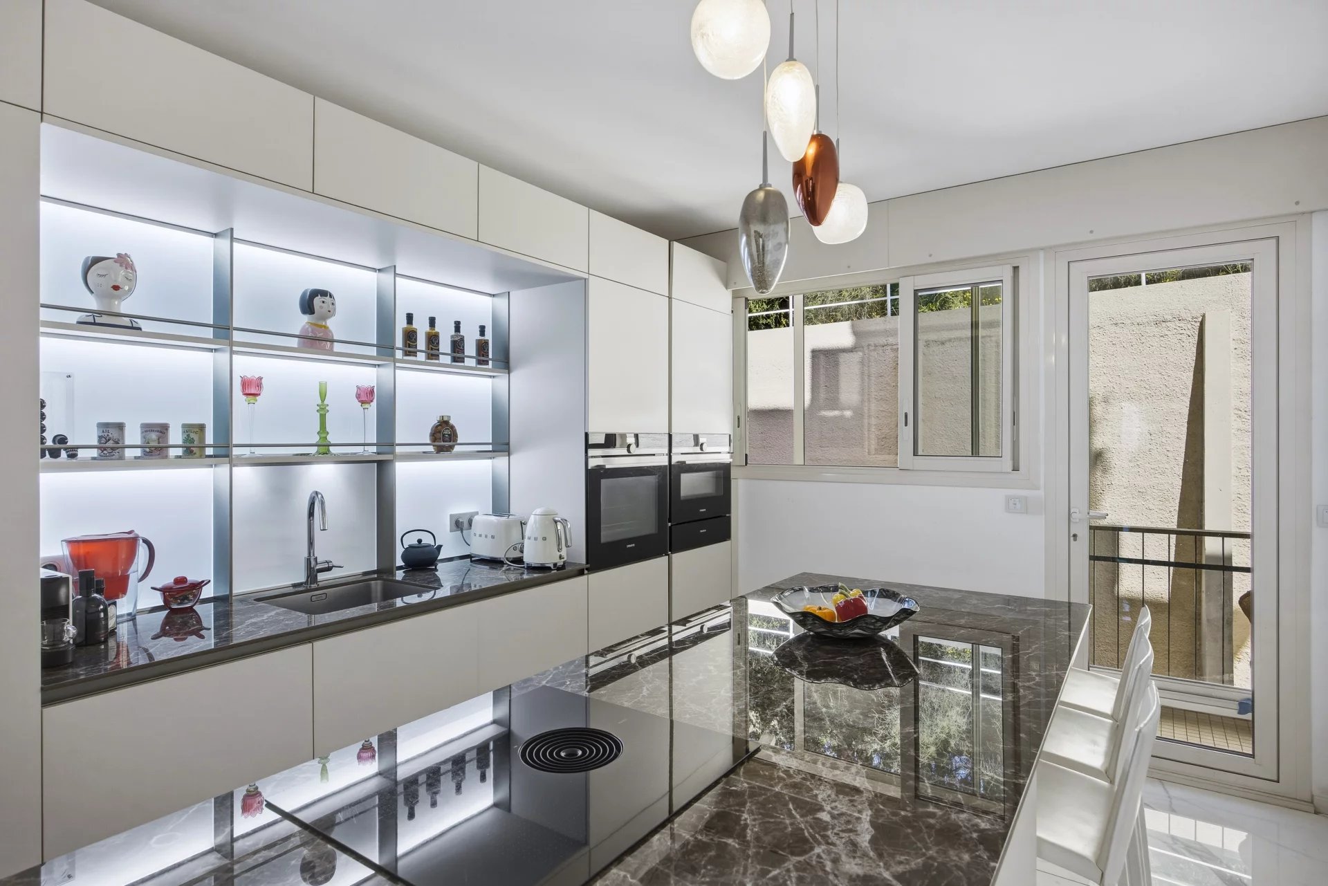 Cuisine d’un appartement de prestige au Cannet Cuisine moderne avec plan de travail en marbre et éclairage design dans un appartement de luxe.