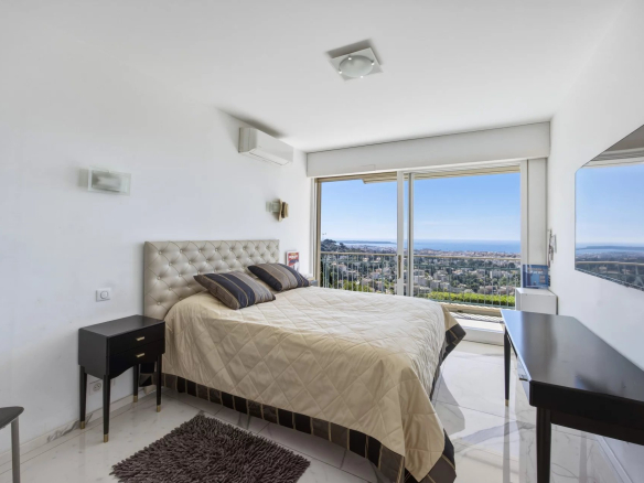 Chambre d'un appartement avec vue mer, lit double et décor moderne au Cannet.