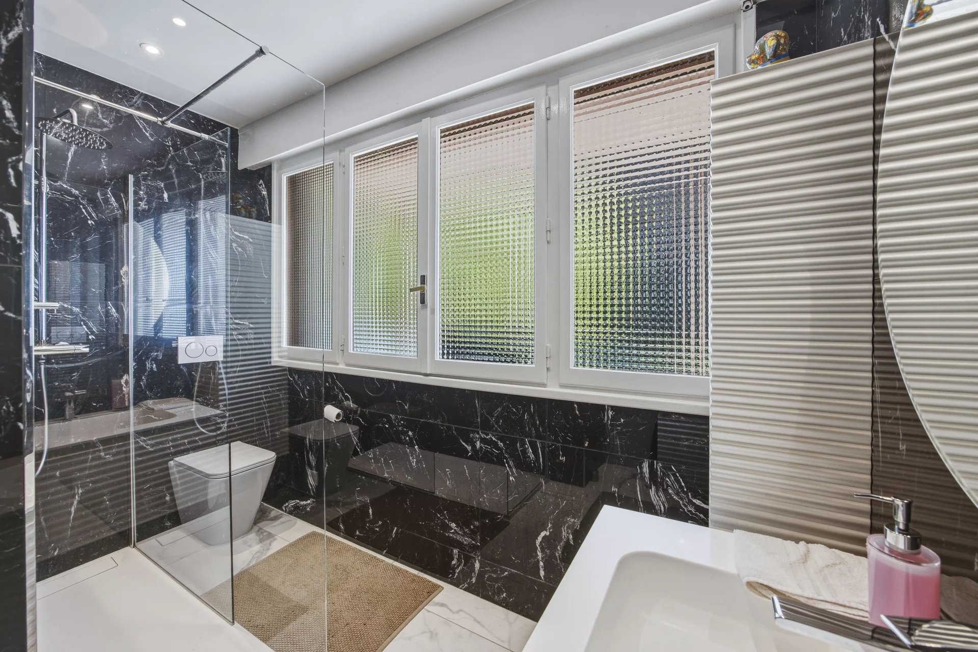 Salle de bain moderne Salle de bain moderne avec douche en verre et carrelage noir et blanc.