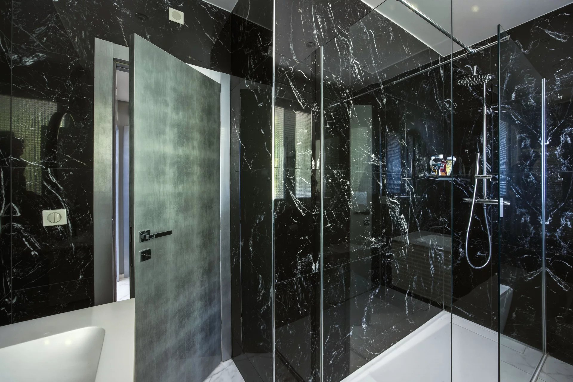 Salle de bain moderne Salle de bain moderne avec douche en verre et murs en marbre noir.