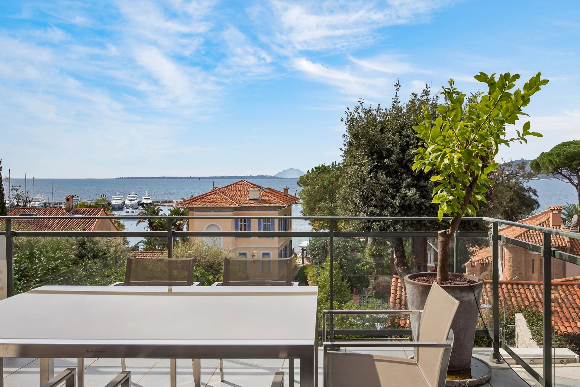 Terrace with sea view in Cap d'Antibes Apartment terrace with sea view in Cap d'Antibes, surrounded by houses and greenery.