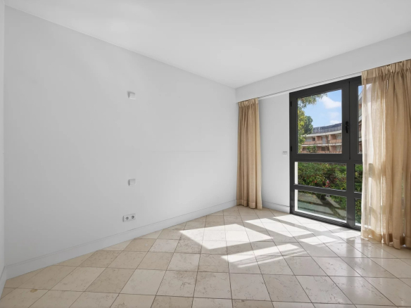 Interior of an empty apartment with windows and tiled floor in Antibes.